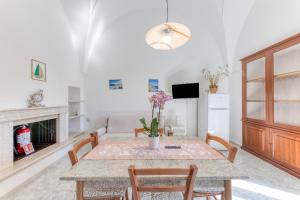 ein Wohnzimmer mit Tisch, Stühlen und Sofa in der Unterkunft Da lu Pira in Patù