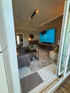 a living room with a couch and a tv at BergÁs in Njarðvík