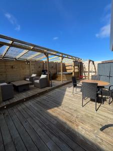 a wooden deck with a table and chairs on it at BergÁs in Njarðvík