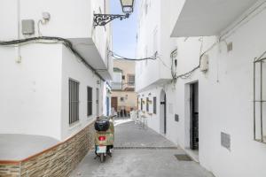 a scooter parked in an alley between two buildings at Playa de Conil in Conil de la Frontera