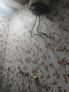 a bathroom with a wall with flowers on it at Hotel Raghunandan Palace in Phata