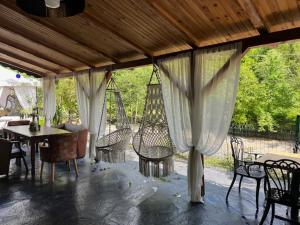 a patio with chairs and a table and a swing at Lapera Otel in Borçka