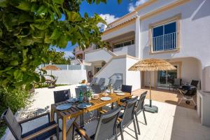 a patio with a wooden table and chairs at Casa Alvor in Alvor