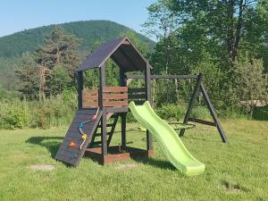 a playground with a slide in the grass at ORLIK - pokoje gościnne in Uście Gorlickie