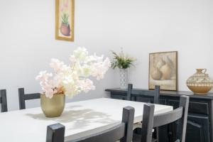 a dining room table with a vase of flowers on it at Playa de Conil in Conil de la Frontera +14 photos