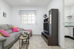 a living room with a couch and a tv at Playa de Conil in Conil de la Frontera