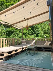 a patio with a bench and a table on a deck at Camping La Dune Blanche - Daly's home in Camiers