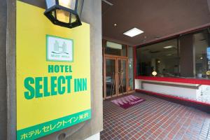 Select Inn Yonezawa في يونيزاوا: لافتة نزل حديدية على جانب مبنى
