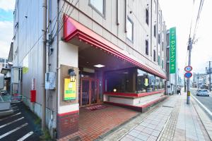 Select Inn Yonezawa في يونيزاوا: مبنى على شارع المدينة فيه محل