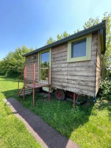 a tiny house on a trailer in the grass at Glamping Casetta sul lago 2 in Albairate