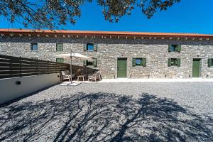 a brick building with a table and an umbrella at Twin Olive Villas in RhodesRhodes