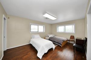 a bedroom with a bed and a chair and two windows at Lofty Grace Home 2 in Richmond