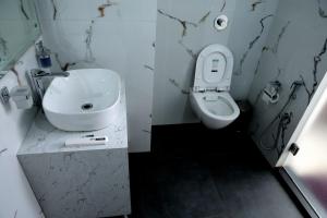 a bathroom with a sink and a toilet at Hotel Maurya Greens in Banbāsa