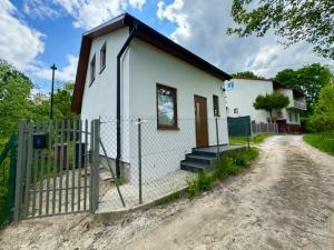 a small white house with a fence and a dirt road at Dom Skośna Kraśnik in Kraśnik