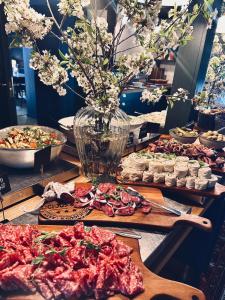 a table with plates of food and a vase of flowers at Hotell Miskarp in Mjölby
