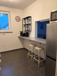 a kitchen with a counter with stools and a refrigerator at Ruhiges City-Apartment mit Balkon in Selb +8 photos