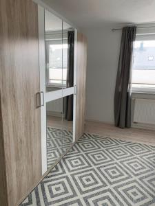 a room with a door and a hallway with a mirror at Ruhiges City-Apartment mit Balkon in Selb