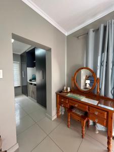 a room with a mirror and a dressing table at Peace Lily Garden Cottage in George