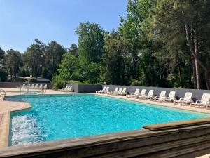 a swimming pool with lounge chairs and a swimming pool at Camping La Dune Blanche - Daly's home in Camiers