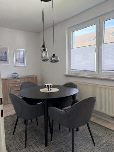 a dining room with a black table and chairs at Ruhiges City-Apartment mit Balkon in Selb