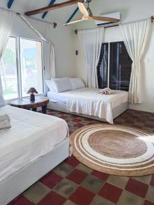 a bedroom with two beds and a ceiling fan at Casa Martine in El Cuyo