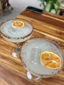 two cocktails on a wooden table with an orange slice at Casa Martine in El Cuyo