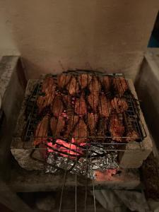 a bunch of meat cooking on a grill at Casa Martine in El Cuyo