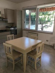 a kitchen with a wooden table and chairs in it at CasaDiFlavio in Torvaianica +13 photos