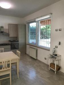 a kitchen with a table and a table and a window at CasaDiFlavio in Torvaianica