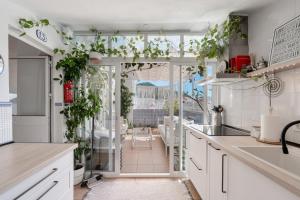 a kitchen with plants on the walls and a window at Casa D’Amelia in Ojén +26 photos