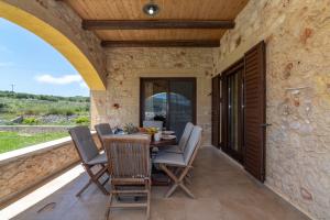 a dining room with a table and chairs on a patio at Villa Chrysseva in Plátanos