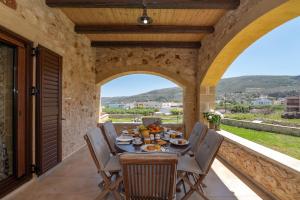an outdoor dining room with a table and chairs at Villa Chrysseva in Plátanos