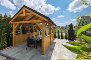a wooden gazebo with a table and chairs at Aparthotel Białka SKI, Odkryj-Bialke in Białka Tatrzańska +102 photos