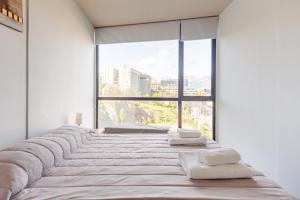 a bedroom with a large bed with towels on it at Kóor Stays - Australis in Ushuaia