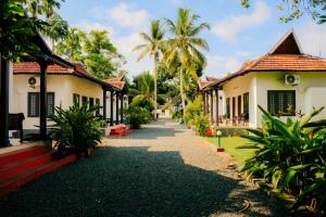 a walkway through the courtyard of a resort at Winterfeel Venice Resort By Neon Nest in Alleppey
