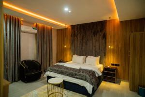 a hotel room with a bed and a chair at Trev Hotels and Suites in Asaba +23 photos