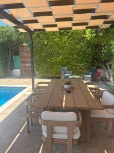 a wooden table and chairs under a wooden umbrella at Villa Talya in Peyia