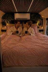 a man and a woman sitting on a bed at Bed&Bus met dakterras in Rucphen