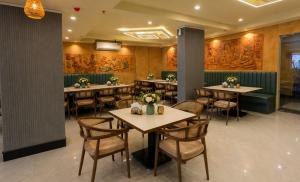 a restaurant with tables and chairs and paintings on the walls at Sabu's Grand Royale - Thampanoor in Trivandrum