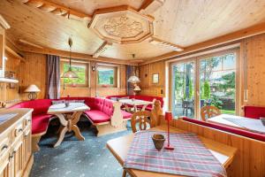 a living room with red couches and tables at Gästehaus Tanneck mit Hallenbad in Reit im Winkl