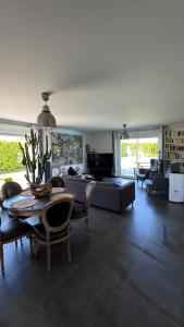 a living room with a couch and a table at Villa Troyes piscine chauffée sans vis à vis et jacuzzi massant in Saint-André-les-Vergers