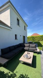 a living room with a couch and a table at Villa Troyes piscine chauffée sans vis à vis et jacuzzi massant in Saint-André-les-Vergers