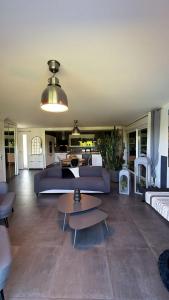 a living room with a blue couch and tables at Villa Troyes piscine chauffée sans vis à vis et jacuzzi massant in Saint-André-les-Vergers