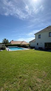 a large yard with a house and a swimming pool at Villa Troyes piscine chauffée sans vis à vis et jacuzzi massant in Saint-André-les-Vergers