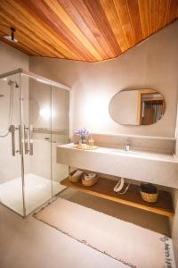 a bathroom with a shower and a sink and a mirror at Pousada Fazenda Caetés in Camboriú +92 photos