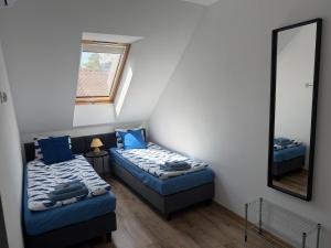 a small room with two beds and a mirror at Apartamenty Dana in Pustkowo
