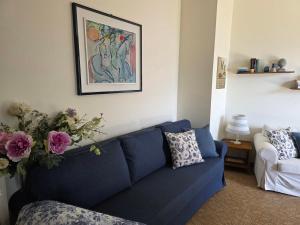 a blue couch in a living room with a vase of flowers at Ca Maria Celeste Apartment in Bellagio