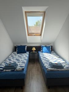 two twin beds in a room with a window at Apartamenty Dana in Pustkowo