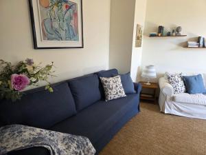 a living room with a blue couch and a white chair at Ca Maria Celeste Apartment in Bellagio