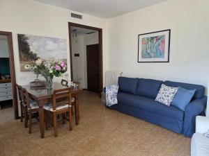 a living room with a blue couch and a table at Ca Maria Celeste Apartment in Bellagio